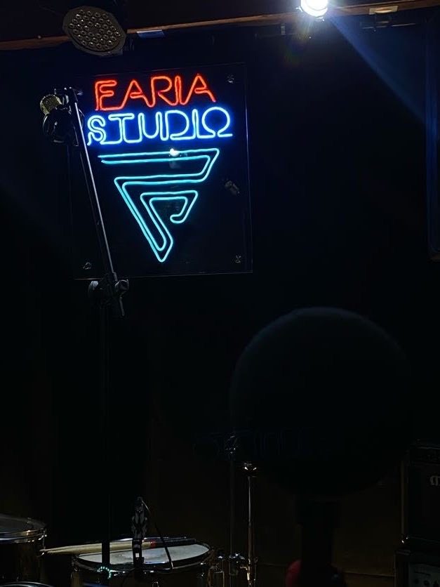 A placa neon do Faria Studio instalada na sala