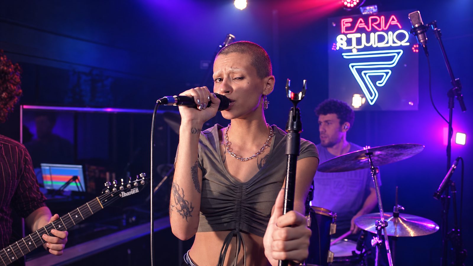 Vocalista e banda tocando ao vivo sob a placa neon do Faria Studio