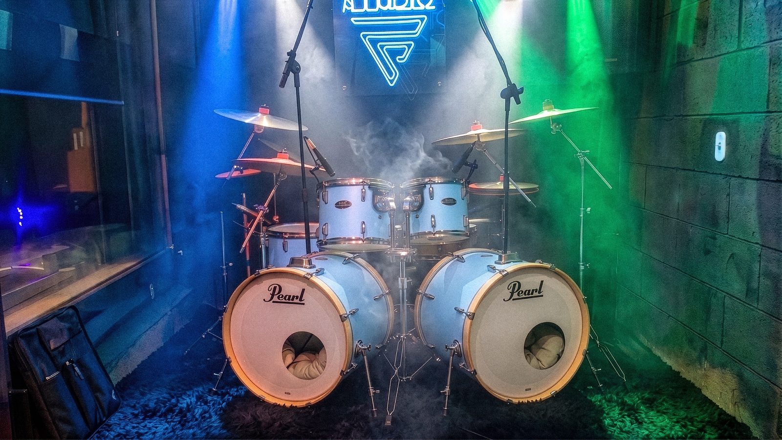 Bateria Pearl sob luzes coloridas e fumaça no Faria Studio